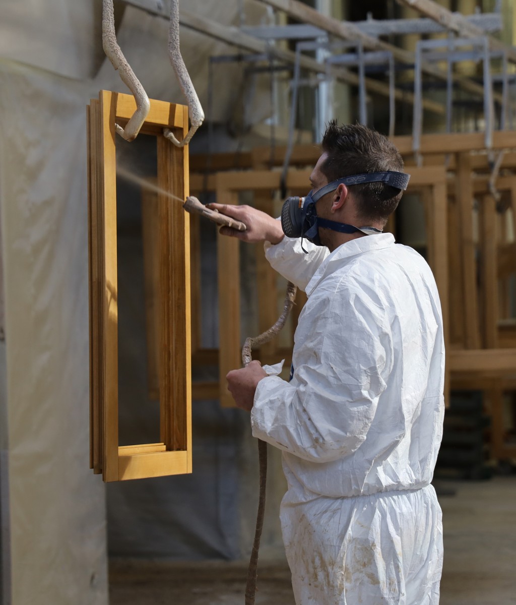 Un homme qui peint un cadre de fenêtre